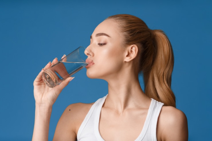 donna con coda che beve bicchiere acqua