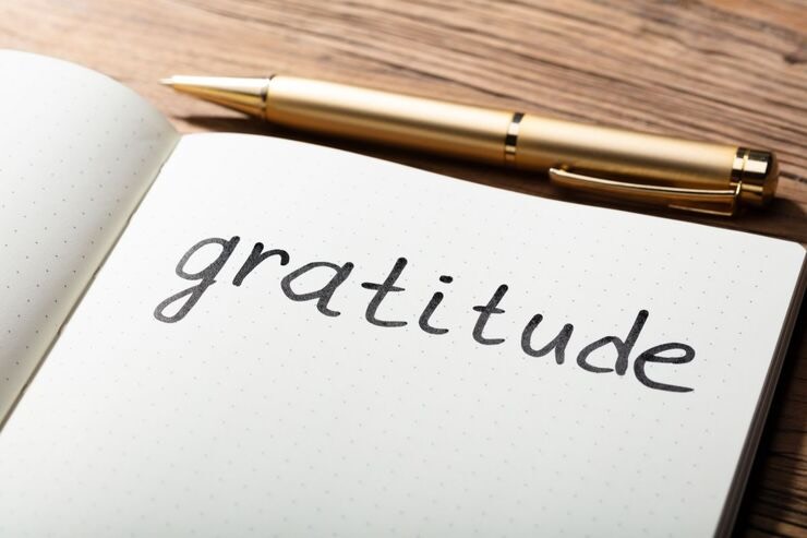 Foglio con scritto "gratitudine", penna oro