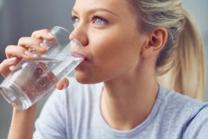 donna bionda che beve acqua