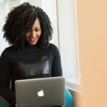 Donna con un portatile sulle ginocchia