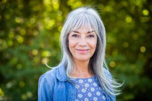 Donna felice con lunghi capelli grigi e bianchi e frangetta