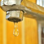 Rubinetto dell'acqua con goccia che cade