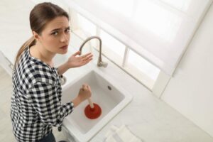 Donna corrucciata che cerca di sgorgare lavandino